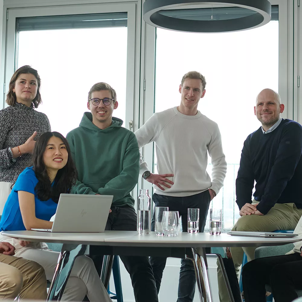 Colleagues are together in the office and look at a point outside the picture