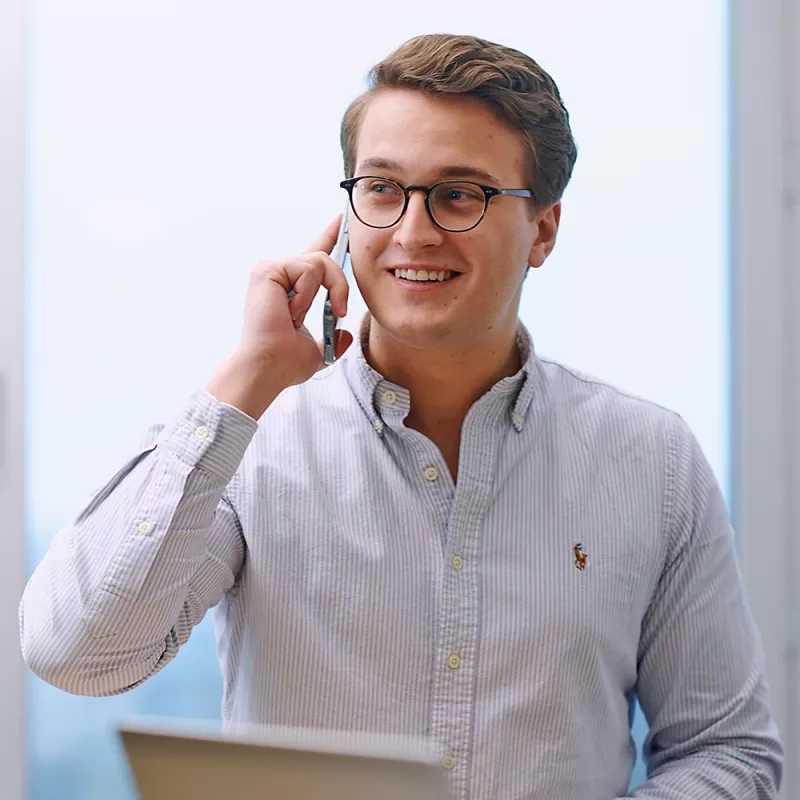 A young consultant talks on his smartphone