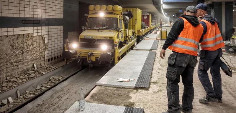 Construction workers beside transportation van/train