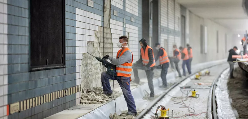 Construction workers tiling a wall