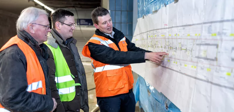 3 Men discuss technical drawing