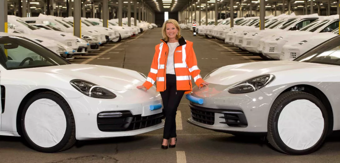 Frau steht neben 2 Autos