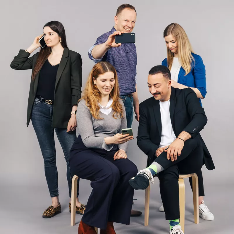 Several high-spirited colleagues are using their smartphones