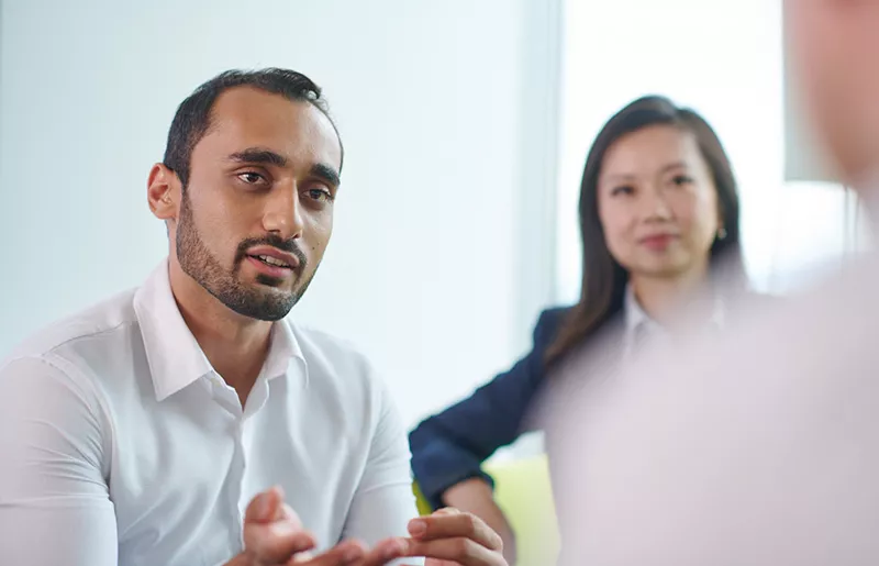 A man and a woman discussing with a person outside the picture
