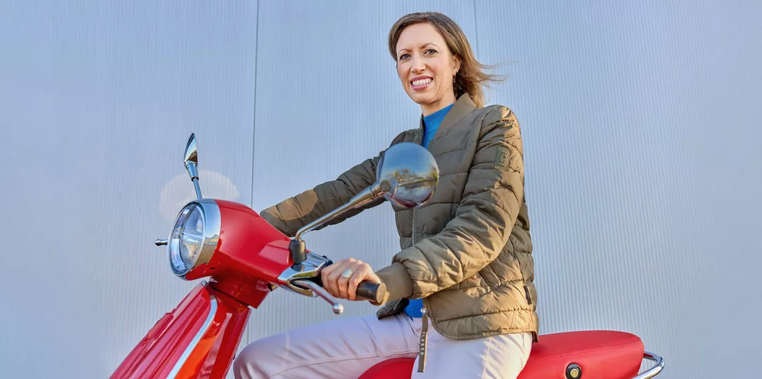 woman driving a red vespa