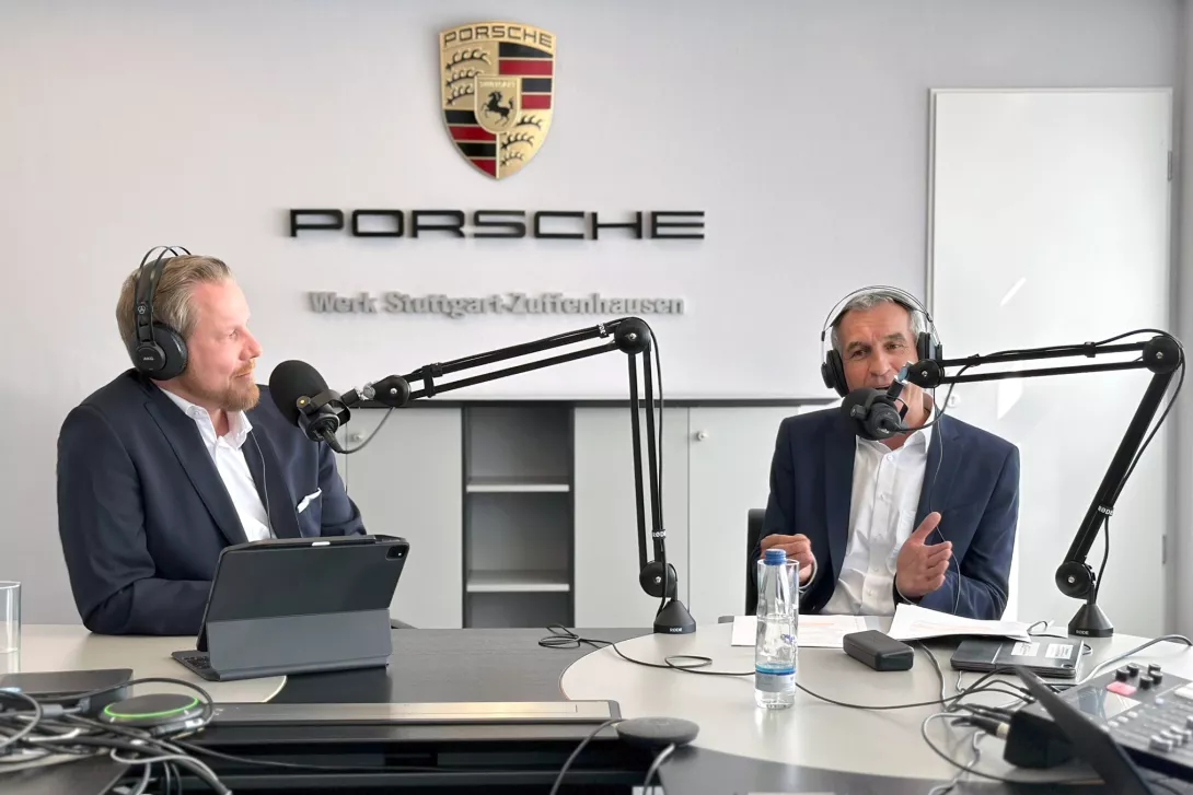 Two People talking over Headphones and Microfons, with a Porsche Zuffenhausen background